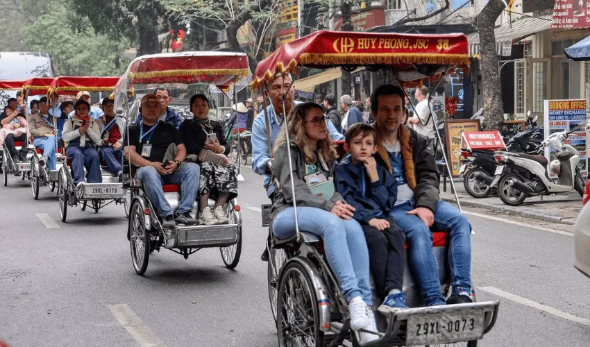 Travelers enjoying a private cyclo tour through Hanoi Vietnam