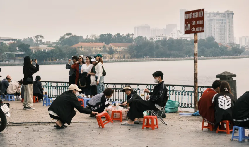Travelers enjoying Hanoi street food on a Vietnam food tour route